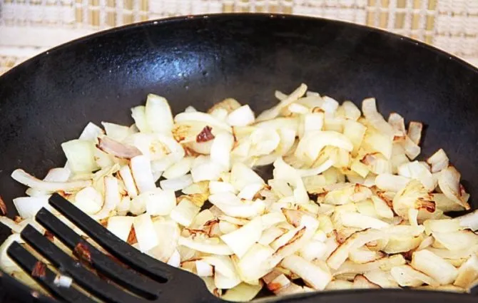 Засыпаем шинкованный полукольцами лук, всё также перемешивая, обжариваем еще 2-3 минуты.